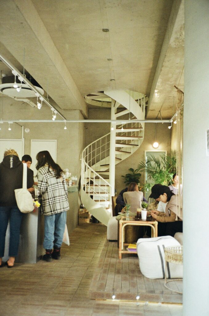 A modern cafe interior with a distinctive spiral staircase and relaxed seating area.